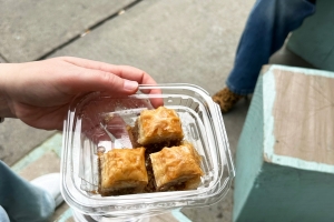 Overhead view of a small tray of baklava above a city sidewalk